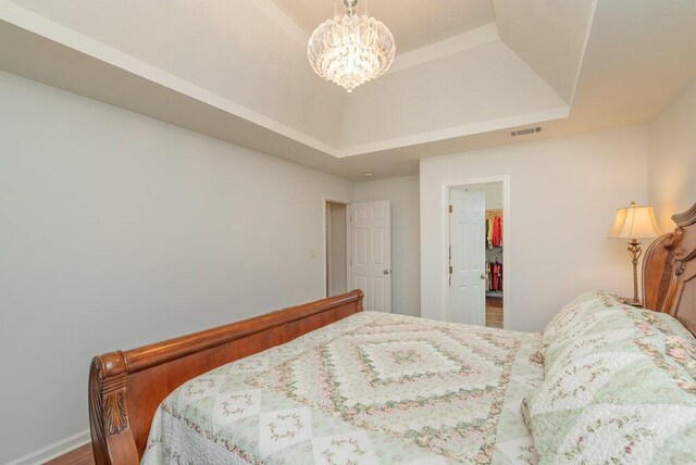 2108 Glenn Fls, Grovetown, GA 30813 - bedroom featuring a raised ceiling, a chandelier, and wood finished floors