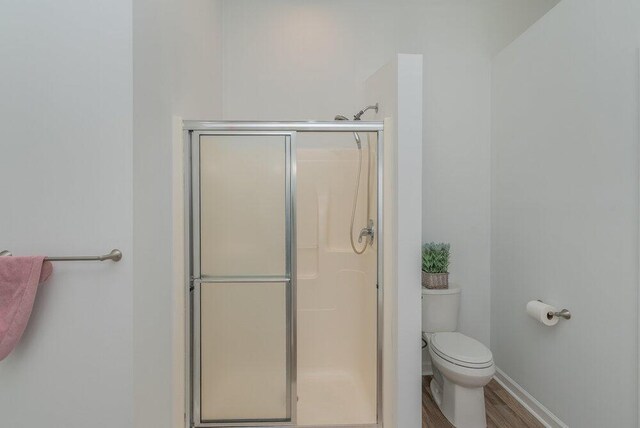 2108 Glenn Fls, Grovetown, GA 30813 - bathroom with a stall shower, toilet, wood finished floors, and baseboards