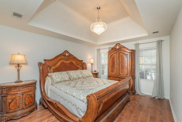 2108 Glenn Fls, Grovetown, GA 30813 - bedroom with a tray ceiling, a chandelier, wood finished floors, and multiple windows