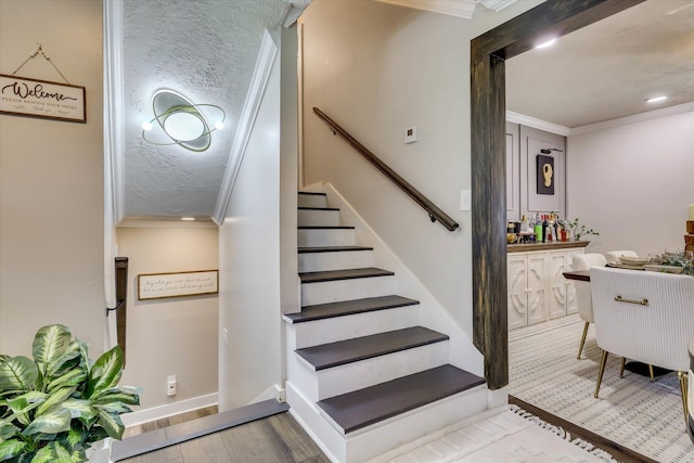 2206 Sandra Ct, Augusta, GA 30906 - stairway with crown molding, wood finished floors, a textured ceiling, a bar, and baseboards