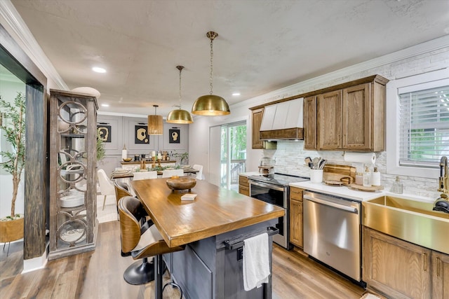 2206 Sandra Ct, Augusta, GA 30906 - kitchen with appliances with stainless steel finishes, custom range hood, a kitchen island, ornamental molding, and a sink