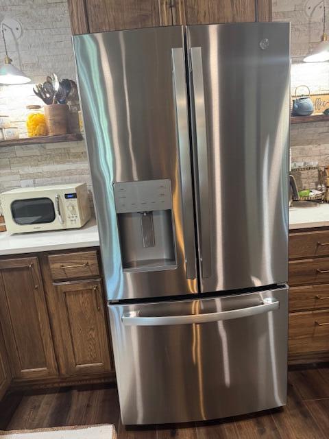 2206 Sandra Ct, Augusta, GA 30906 - kitchen with stainless steel fridge, dark wood-style floors, light countertops, and white microwave