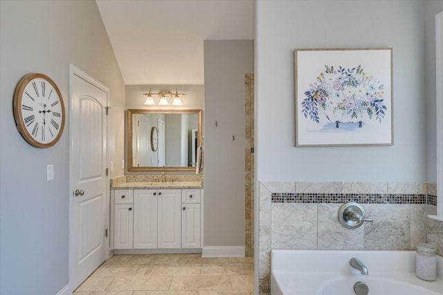 bathroom with a garden tub, vanity, and vaulted ceiling