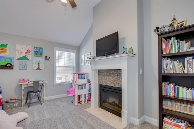 game room featuring baseboards, carpet, vaulted ceiling, a tile fireplace, and a ceiling fan