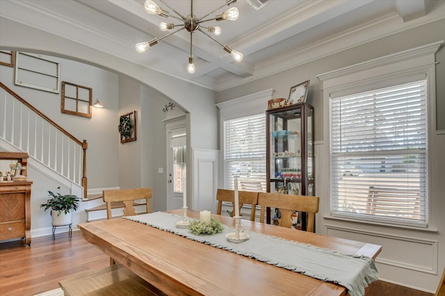 dining room with stairs, light wood-style flooring, an inviting chandelier, arched walkways, and coffered ceiling