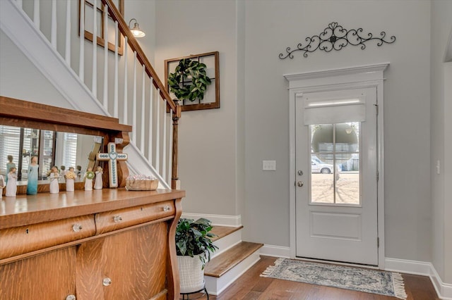 entryway featuring stairs, baseboards, and dark wood-style flooring