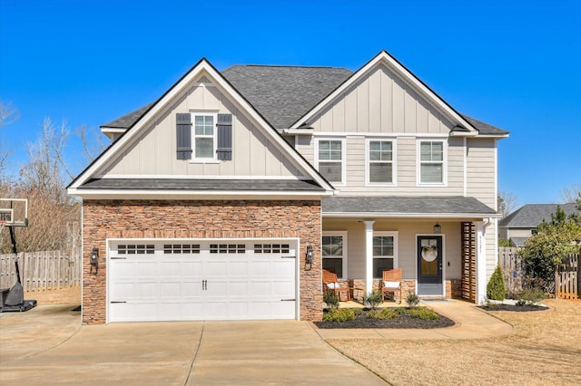 craftsman-style home featuring covered porch, board and batten siding, concrete driveway, and fence