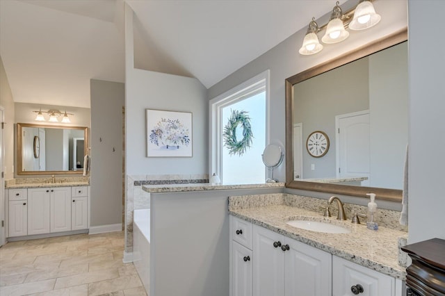 full bathroom with a bath, two vanities, lofted ceiling, and a sink