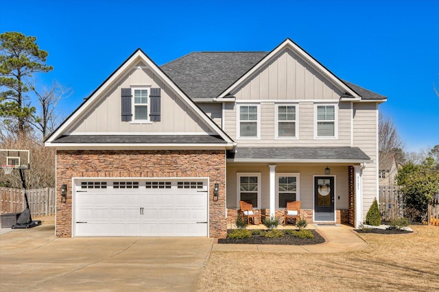 craftsman inspired home featuring covered porch, board and batten siding, driveway, and fence