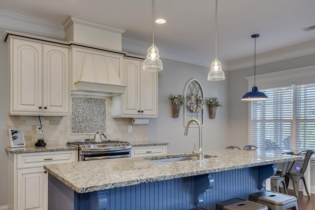 kitchen with decorative backsplash, ornamental molding, stainless steel gas stove, and a sink