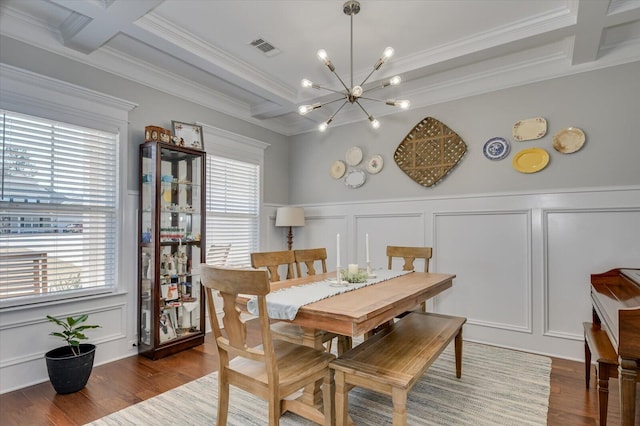 dining room with visible vents, a chandelier, wood finished floors, a decorative wall, and coffered ceiling