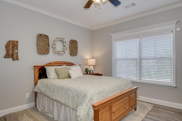 bedroom featuring crown molding, baseboards, visible vents, and ceiling fan