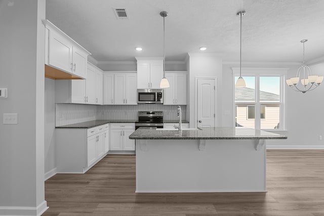 kitchen with sink, white cabinetry, tasteful backsplash, an island with sink, and stainless steel appliances