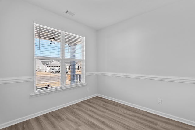 unfurnished room with wood-type flooring and a wealth of natural light