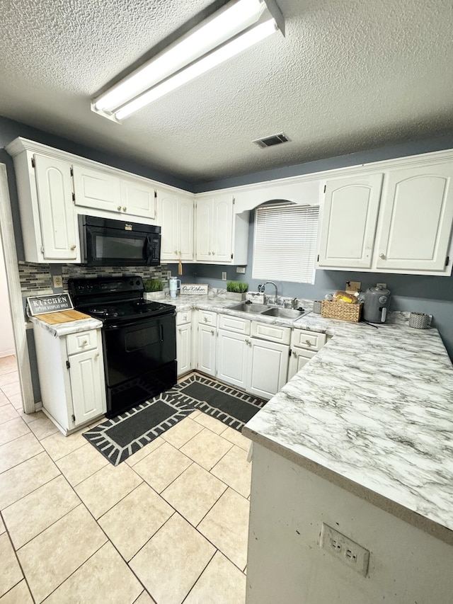 kitchen with black appliances, light tile patterned floors, a textured ceiling, white cabinets, and sink