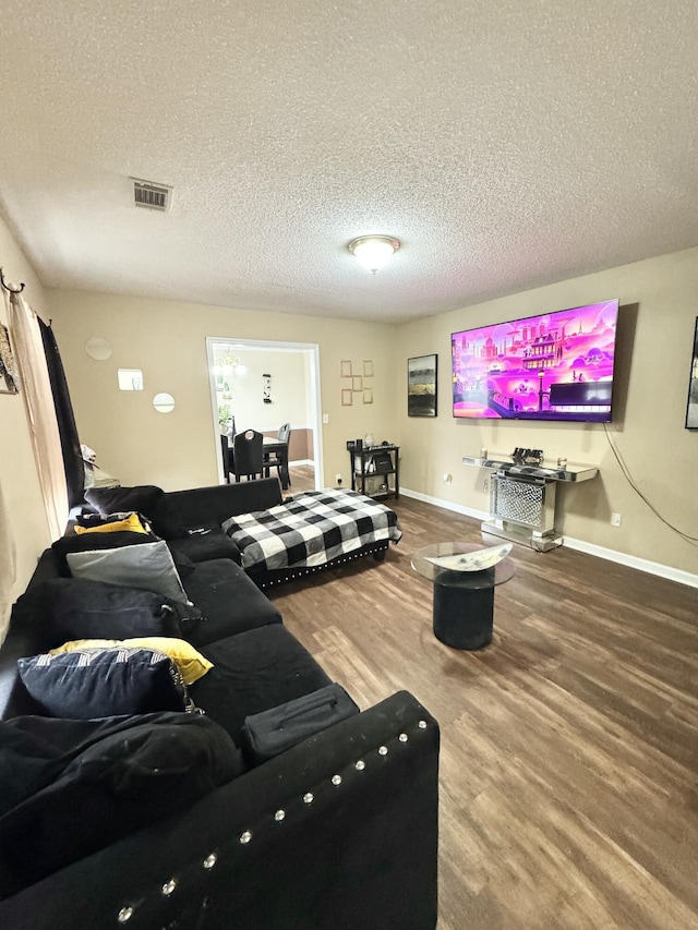 living room with wood-type flooring and a textured ceiling