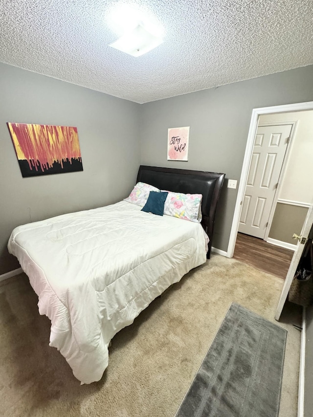 bedroom with a textured ceiling and carpet floors