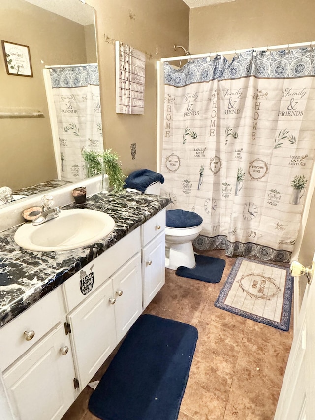 bathroom with toilet, vanity, and a textured ceiling