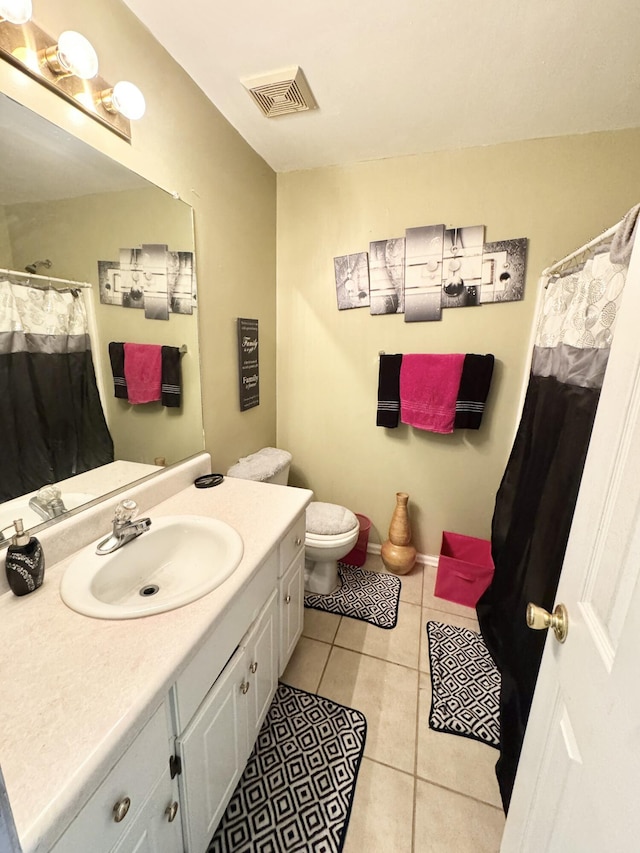 bathroom featuring toilet, tile patterned floors, and vanity