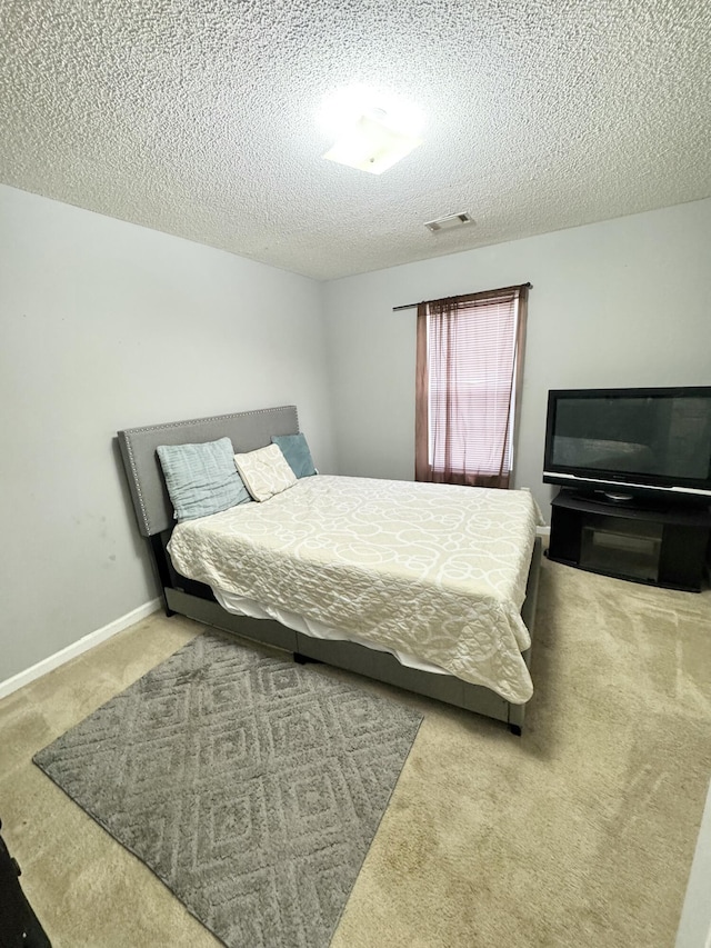 bedroom with carpet floors and a textured ceiling