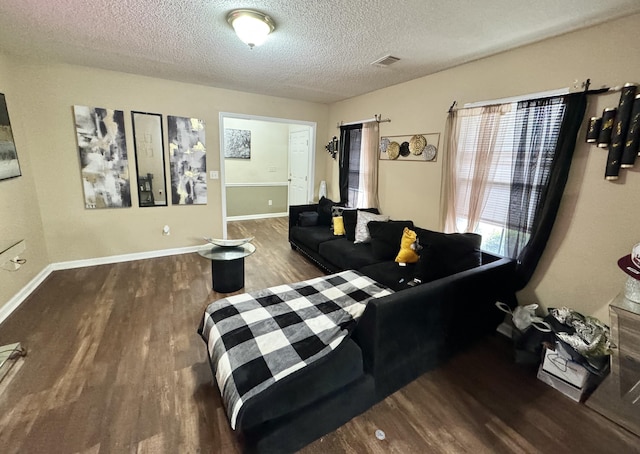 living room with dark hardwood / wood-style flooring and a textured ceiling