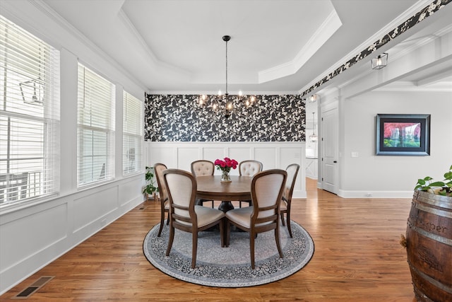 1037 Bartram Rdg, Evans, GA 30809 - dining space with wood finished floors, a chandelier, a tray ceiling, crown molding, and a decorative wall
