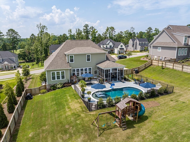 1037 Bartram Rdg, Evans, GA 30809 - back of house with a sunroom, a playground, a fenced backyard, a shingled roof, and a residential view
