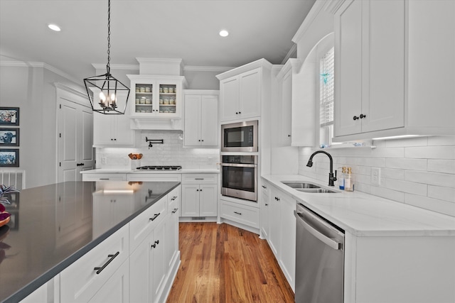 1037 Bartram Rdg, Evans, GA 30809 - kitchen featuring appliances with stainless steel finishes, crown molding, a chandelier, white cabinetry, and tasteful backsplash