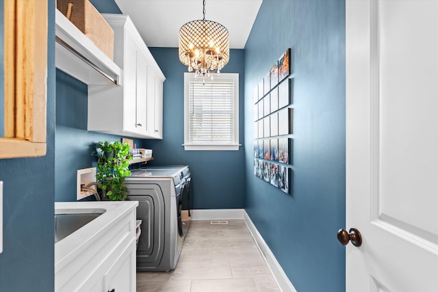 1037 Bartram Rdg, Evans, GA 30809 - washroom featuring independent washer and dryer, a chandelier, cabinet space, and light tile patterned flooring
