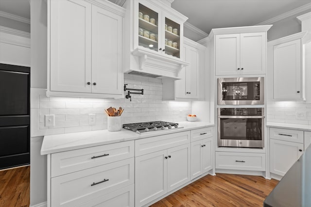 1037 Bartram Rdg, Evans, GA 30809 - kitchen featuring appliances with stainless steel finishes, ornamental molding, light wood-type flooring, and white cabinetry