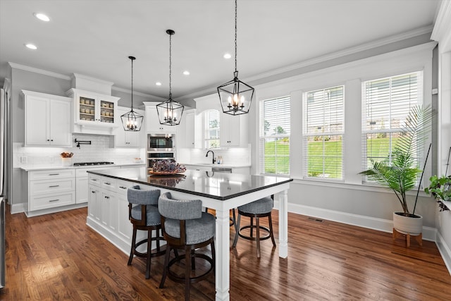 1037 Bartram Rdg, Evans, GA 30809 - kitchen with stainless steel appliances, backsplash, a chandelier, ornamental molding, and a kitchen breakfast bar