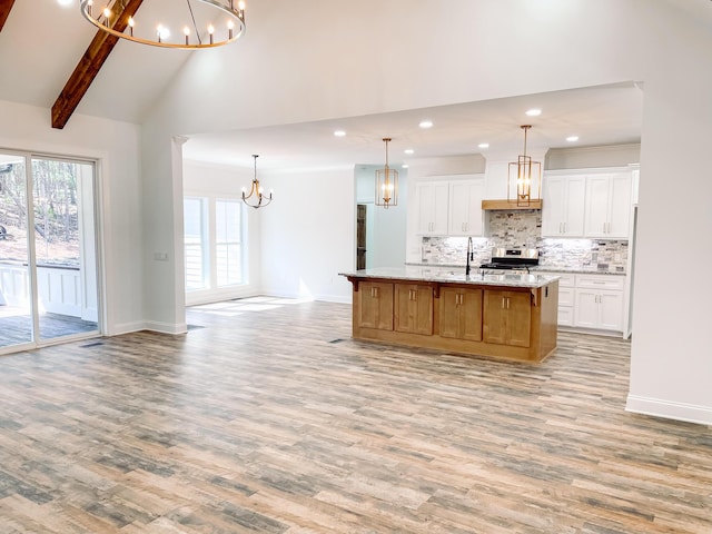 kitchen featuring a chandelier, electric stove, backsplash, and light wood-style flooring