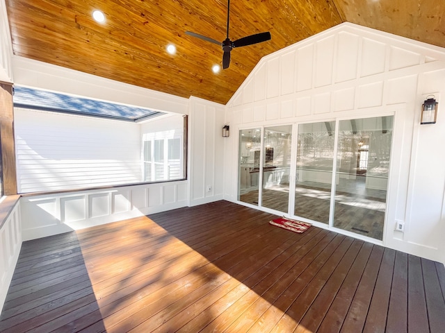 unfurnished sunroom with ceiling fan, wood ceiling, and vaulted ceiling