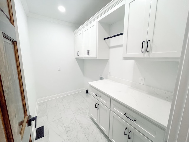 clothes washing area with recessed lighting, baseboards, marble finish floor, ornamental molding, and cabinet space