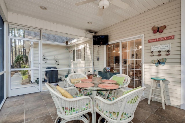 sunroom featuring wood ceiling and ceiling fan