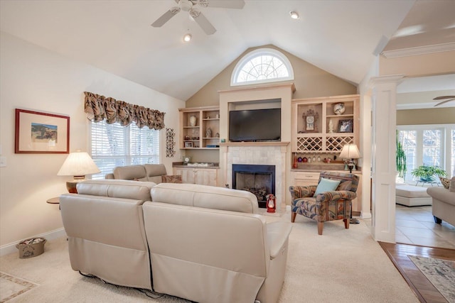 living room with decorative columns, ceiling fan, and a healthy amount of sunlight