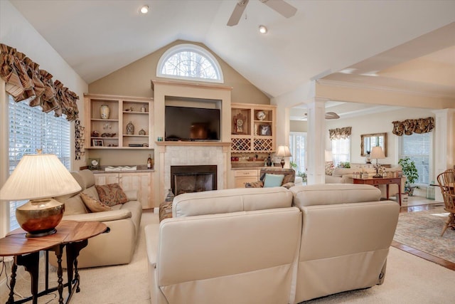 carpeted living room featuring decorative columns, lofted ceiling, ceiling fan, and a fireplace