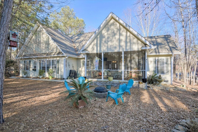 back of house with a sunroom and an outdoor fire pit