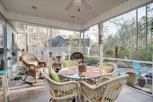 sunroom with ceiling fan, a wealth of natural light, and wood ceiling