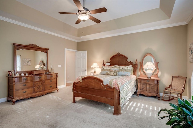 carpeted bedroom with ceiling fan, ornamental molding, and a raised ceiling