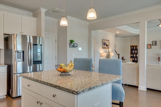 kitchen featuring white cabinetry, stainless steel fridge, and light stone countertops