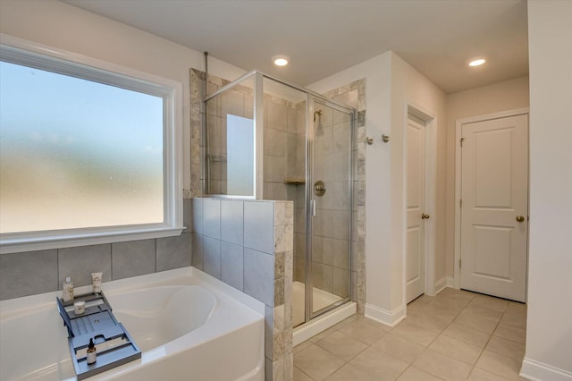 bathroom with separate shower and tub and tile patterned flooring