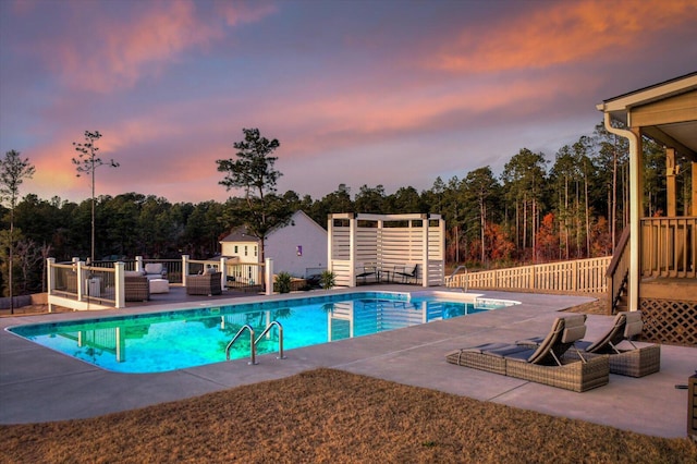 pool at dusk featuring a patio area