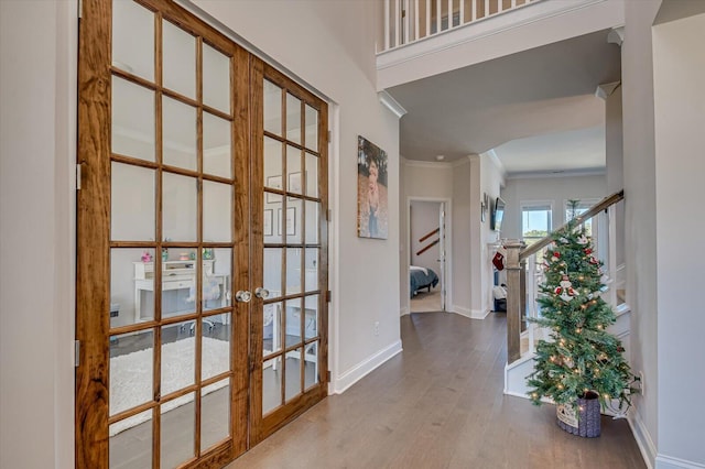 hall featuring hardwood / wood-style flooring, ornamental molding, and french doors