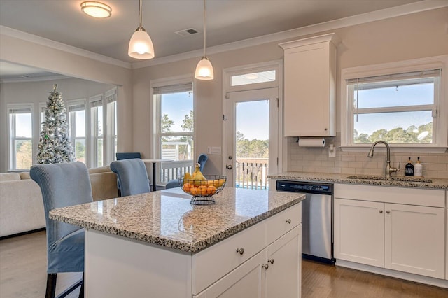 kitchen with dishwasher, sink, a kitchen island, backsplash, and white cabinets