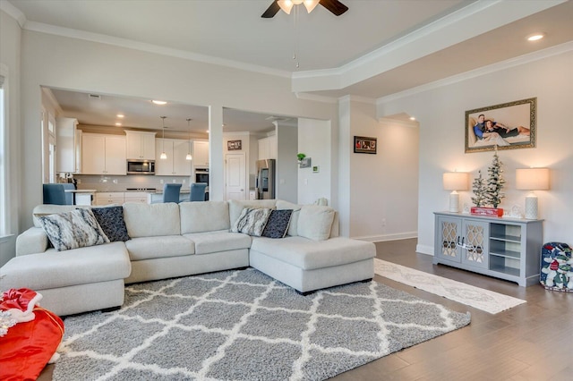 living room featuring hardwood / wood-style flooring, ceiling fan, and ornamental molding