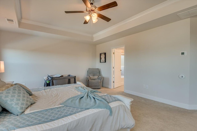 bedroom with ceiling fan, crown molding, light carpet, and a tray ceiling