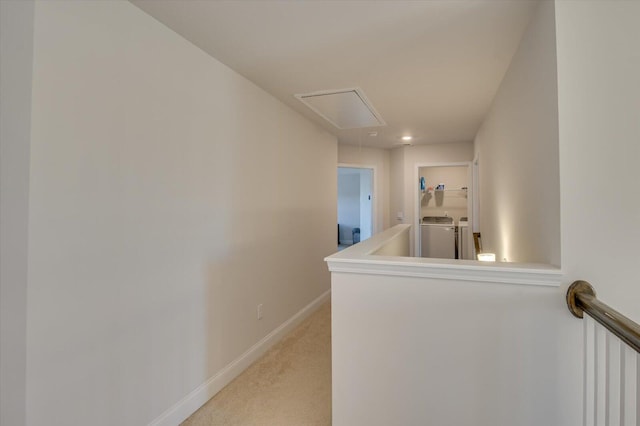 hallway with light carpet and washer and clothes dryer