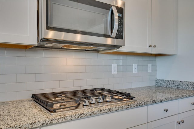 kitchen featuring white cabinetry, stainless steel appliances, and tasteful backsplash