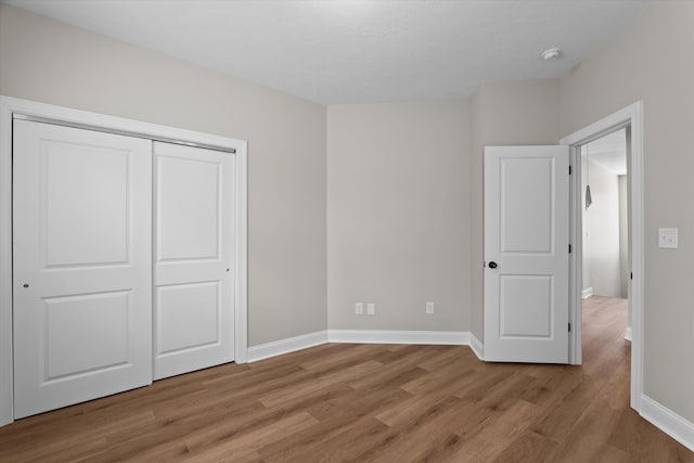 651 Moose Club Rd, Thomson, GA 30824 - unfurnished bedroom featuring light wood-style floors, baseboards, and a closet